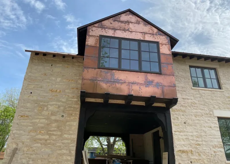 Copper metal panel facade on a stone building for Roof Repair in Eagleton Village